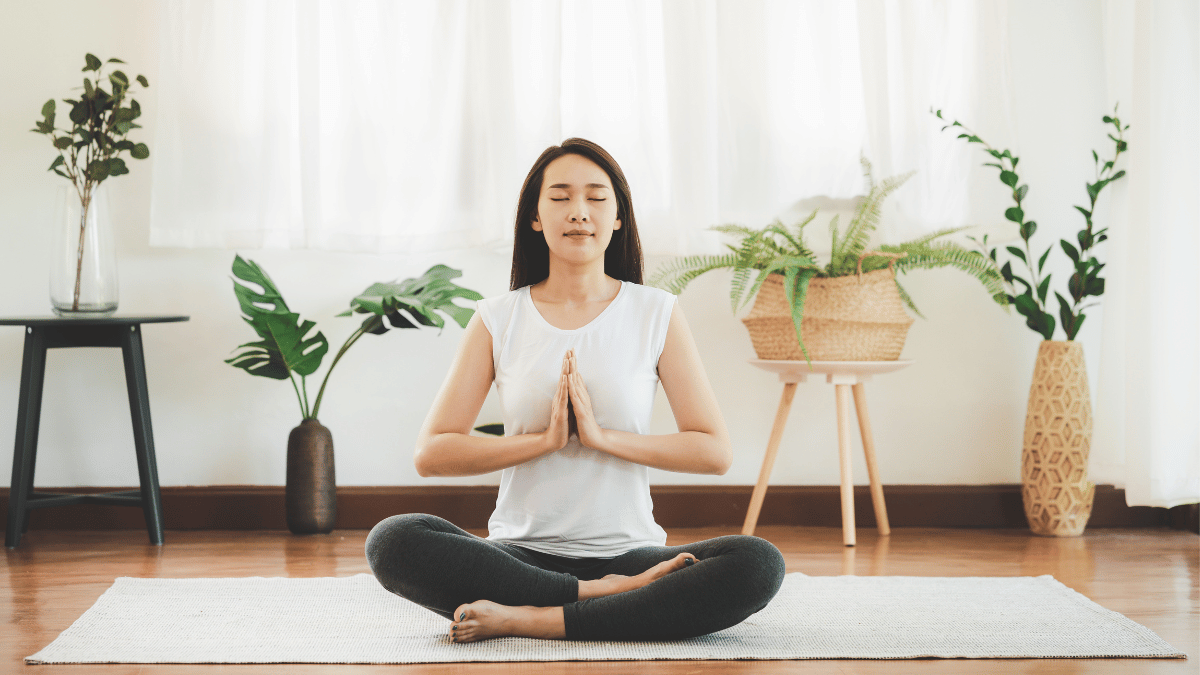 A calm and peaceful image of a woman meditating - a practice that can be incorporated into a morning routine to overcome challenges and start the day right.