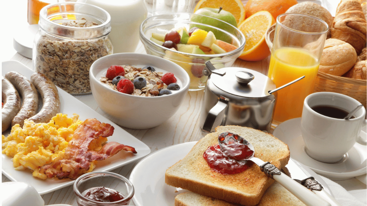 A healthy breakfast consisting of fruits, granola, and a glass of juice, representing a key element of a powerful morning routine.